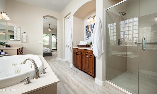 bathroom with hardwood / wood-style flooring, ceiling fan, plus walk in shower, and vanity