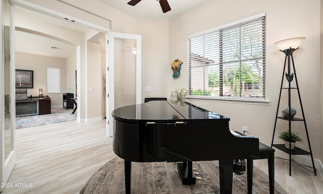 living area featuring light wood-type flooring and ceiling fan