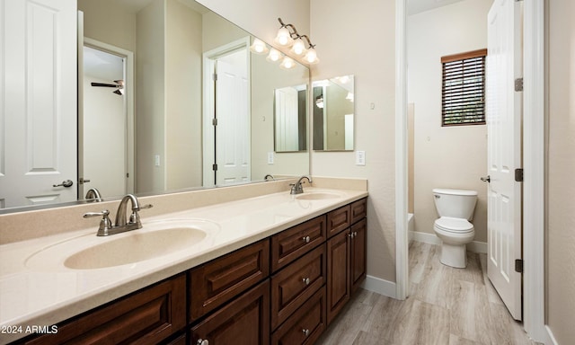 bathroom with a tub to relax in, toilet, vanity, and hardwood / wood-style flooring