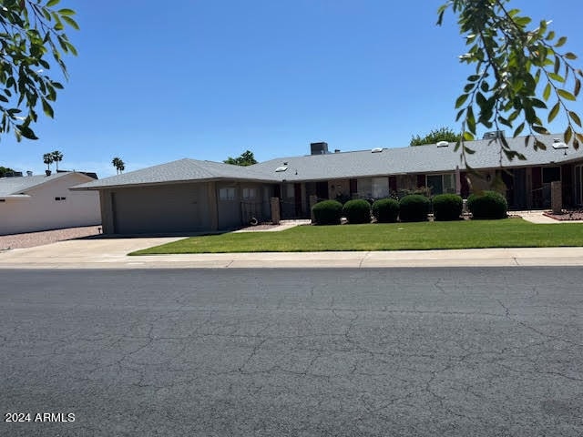 single story home with a garage and a front yard