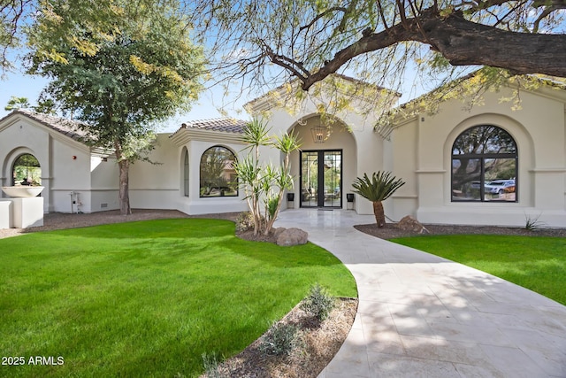 exterior space with stucco siding, french doors, and a front lawn