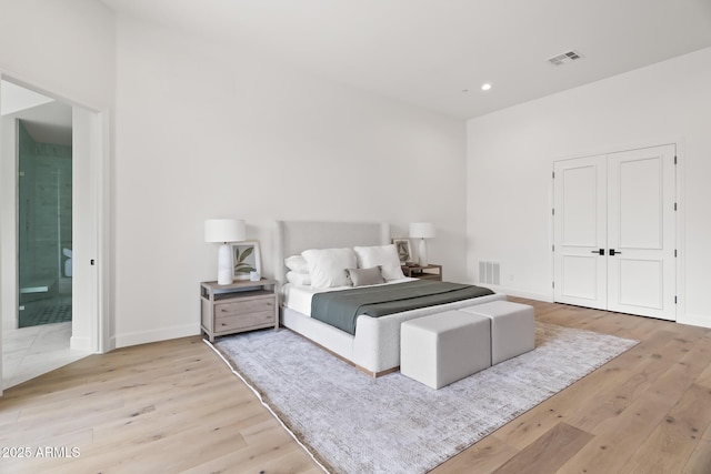 bedroom featuring visible vents, light wood-style flooring, and baseboards