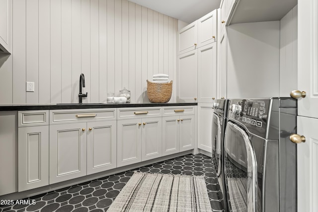 laundry room with washing machine and dryer, cabinet space, and a sink