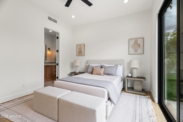 bedroom featuring recessed lighting, baseboards, wood finished floors, and ensuite bathroom