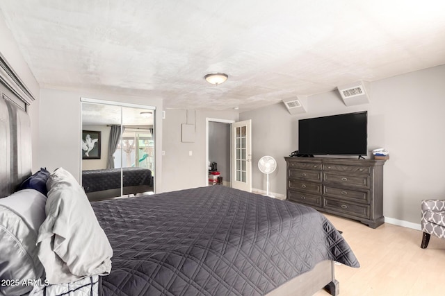 bedroom featuring light wood-type flooring, a closet, and french doors