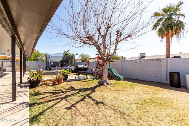 view of yard with a playground and a trampoline