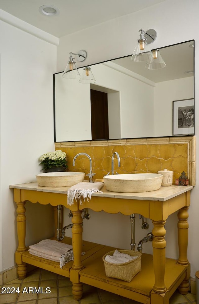 bathroom with tile patterned flooring, sink, and decorative backsplash