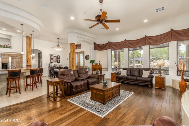 living room with dark wood-type flooring and ceiling fan