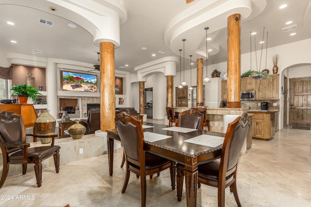 dining room with ceiling fan and ornate columns