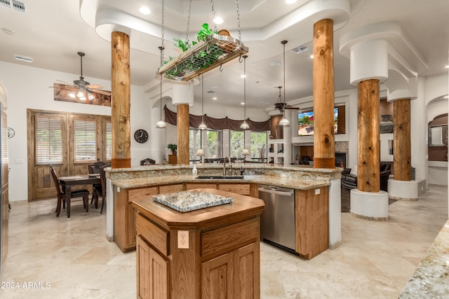 kitchen featuring a center island, decorative light fixtures, dishwasher, and decorative columns