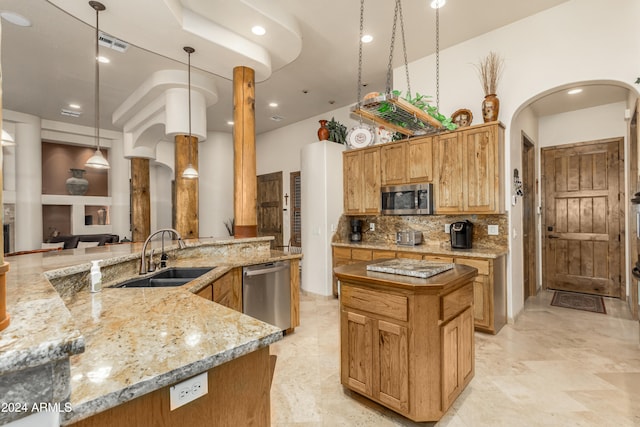 kitchen with light stone counters, appliances with stainless steel finishes, decorative light fixtures, decorative backsplash, and sink