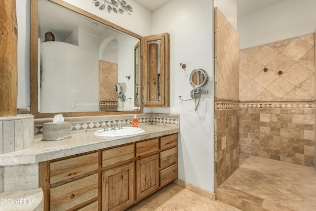 bathroom with vanity and a tile shower