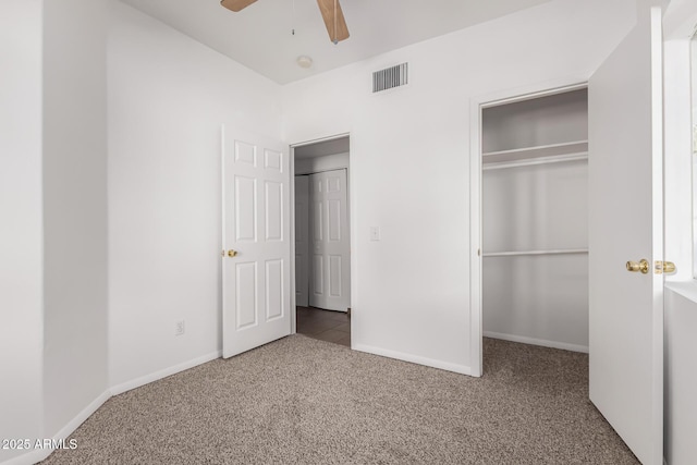 unfurnished bedroom with ceiling fan, light colored carpet, and a closet