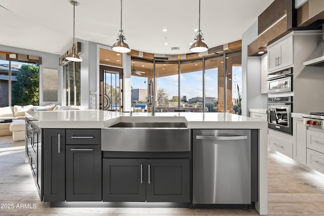 kitchen with white cabinetry, appliances with stainless steel finishes, and an island with sink