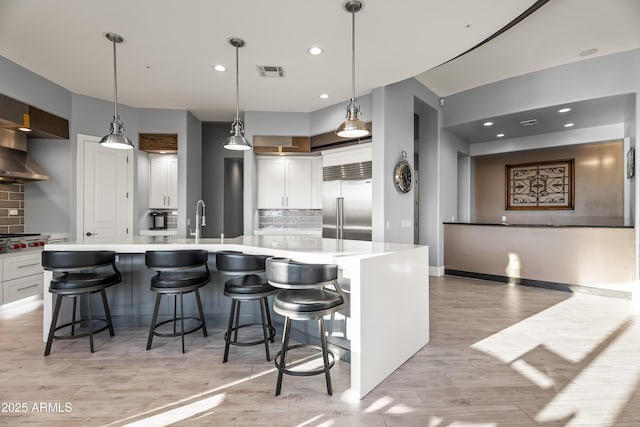 kitchen with stainless steel appliances, white cabinetry, a breakfast bar, and a spacious island