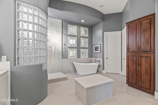 bathroom with vanity, tile patterned floors, plus walk in shower, and tile walls