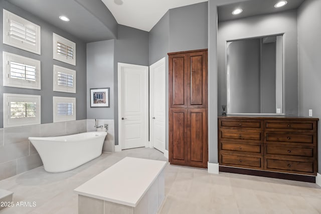 bathroom featuring a washtub and vanity