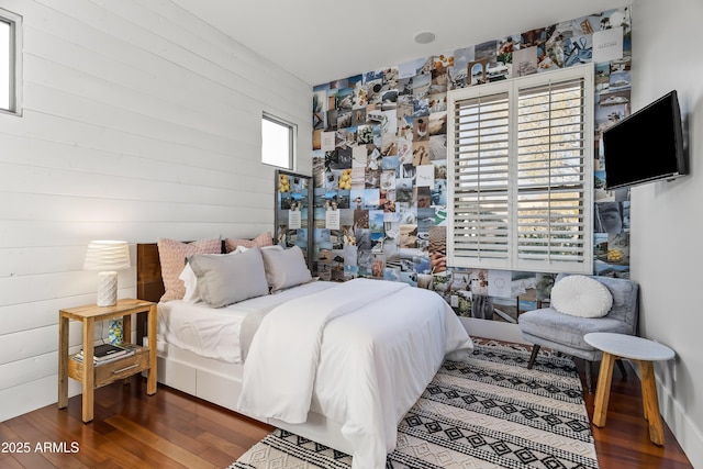 bedroom with wood-type flooring and wood walls