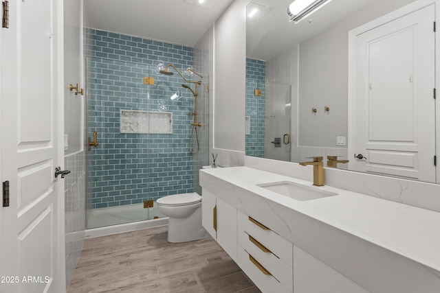 bathroom with an enclosed shower, vanity, hardwood / wood-style flooring, and toilet