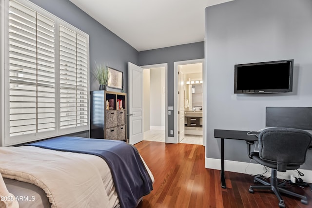 bedroom with ensuite bathroom and hardwood / wood-style floors