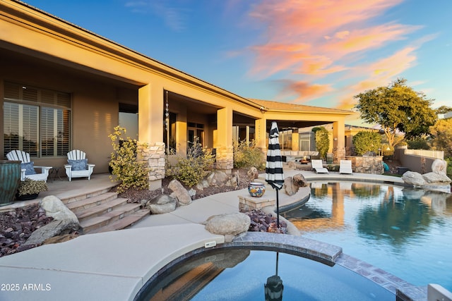 pool at dusk featuring a patio