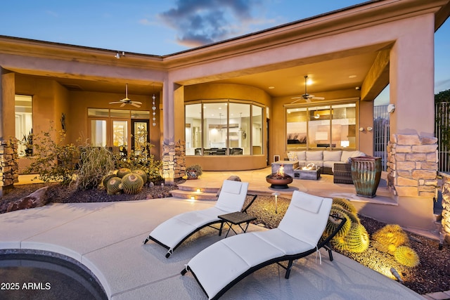 patio terrace at dusk with ceiling fan and outdoor lounge area