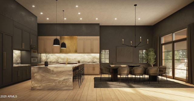 interior space featuring tasteful backsplash, a towering ceiling, light wood-style flooring, hanging light fixtures, and an inviting chandelier