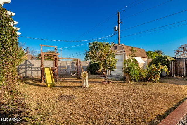 view of yard with a storage shed and a playground