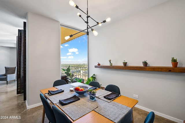 dining space featuring an inviting chandelier and concrete flooring