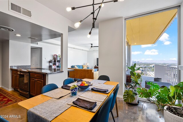 207 W Clarendon Ave Unit 20B, Phoenix, AZ 85013 - dining room with baseboards, expansive windows, ceiling fan, and visible vents