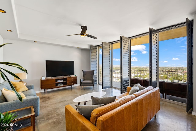 207 W Clarendon Ave Unit 20B, Phoenix, AZ 85013 - living room featuring baseboards, ceiling fan, a wall of windows, and finished concrete floors