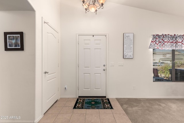 foyer featuring light colored carpet and an inviting chandelier