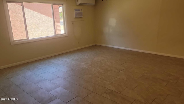 spare room with a wall mounted AC, a wall unit AC, and baseboards