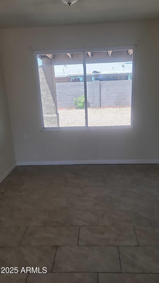 spare room featuring baseboards and tile patterned floors