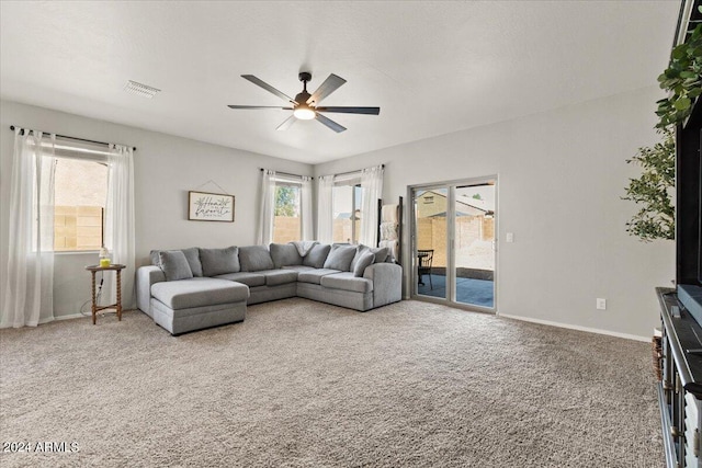 carpeted living room with ceiling fan