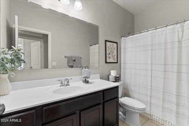 bathroom featuring vanity, tile patterned flooring, and toilet