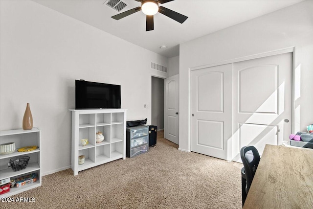 carpeted bedroom with ceiling fan and a closet