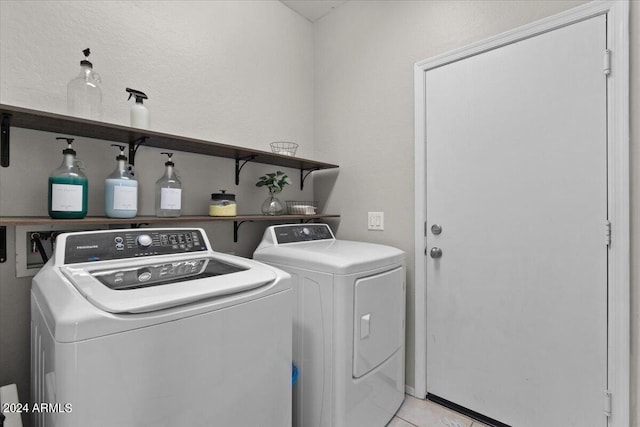 washroom with light tile patterned flooring and washer and dryer