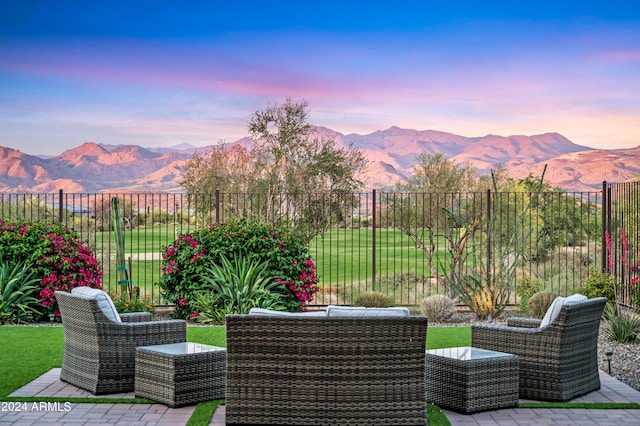 patio terrace at dusk featuring a mountain view and an outdoor living space