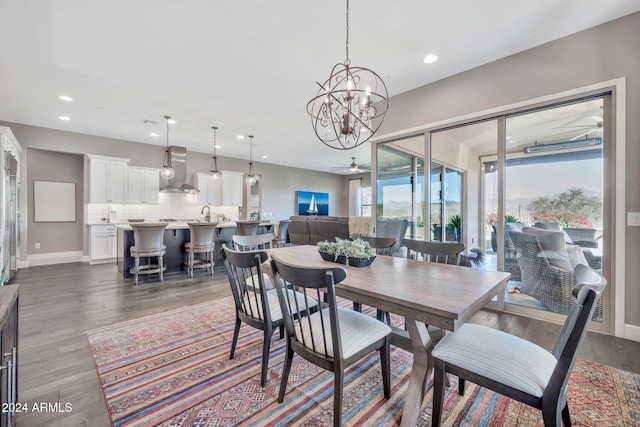 dining area featuring ceiling fan with notable chandelier and dark wood-type flooring