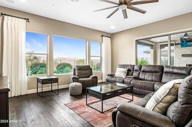 living room with a fireplace, dark hardwood / wood-style floors, and ceiling fan