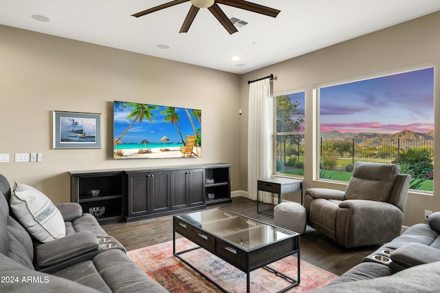 living room featuring ceiling fan and dark wood-type flooring