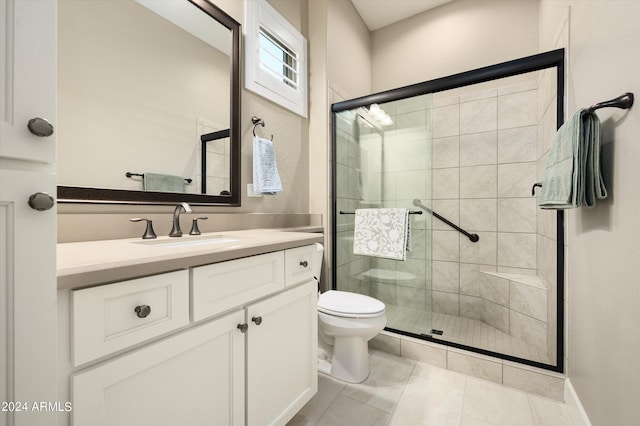 bathroom with tile patterned flooring, vanity, an enclosed shower, and toilet