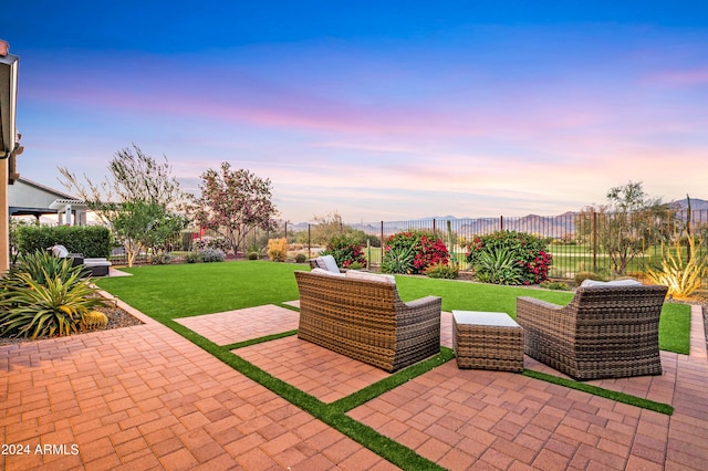 patio terrace at dusk featuring outdoor lounge area and a yard