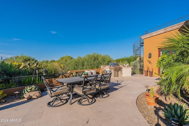 view of patio featuring an outdoor kitchen and a grill