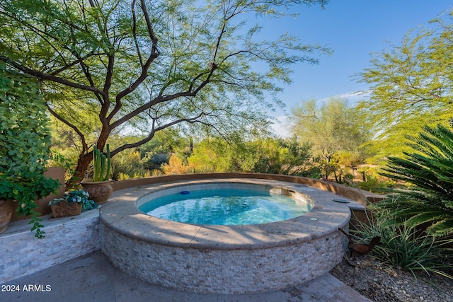 view of swimming pool featuring an in ground hot tub