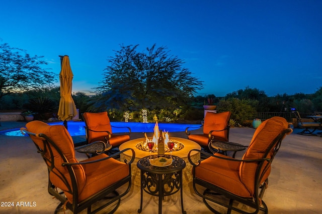 patio terrace at dusk featuring an outdoor fire pit