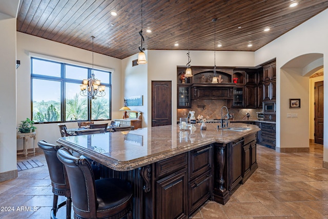 kitchen featuring pendant lighting, sink, a large island, dark brown cabinetry, and wooden ceiling