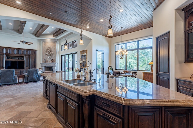 kitchen featuring hanging light fixtures, sink, and a center island with sink