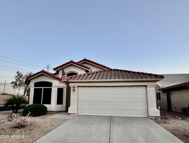 view of front of property featuring a tile roof, an attached garage, driveway, and stucco siding